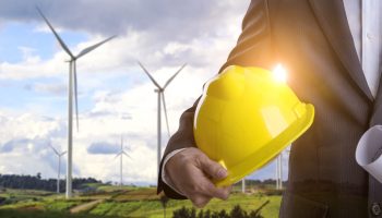 Business man with safety helmet inspects construction sites and The wind turbine of the hill .Concept for industrial technology